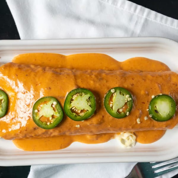 Casa Agave's burrito smothered in orange sauce and topped with fresh jalapeño slices.