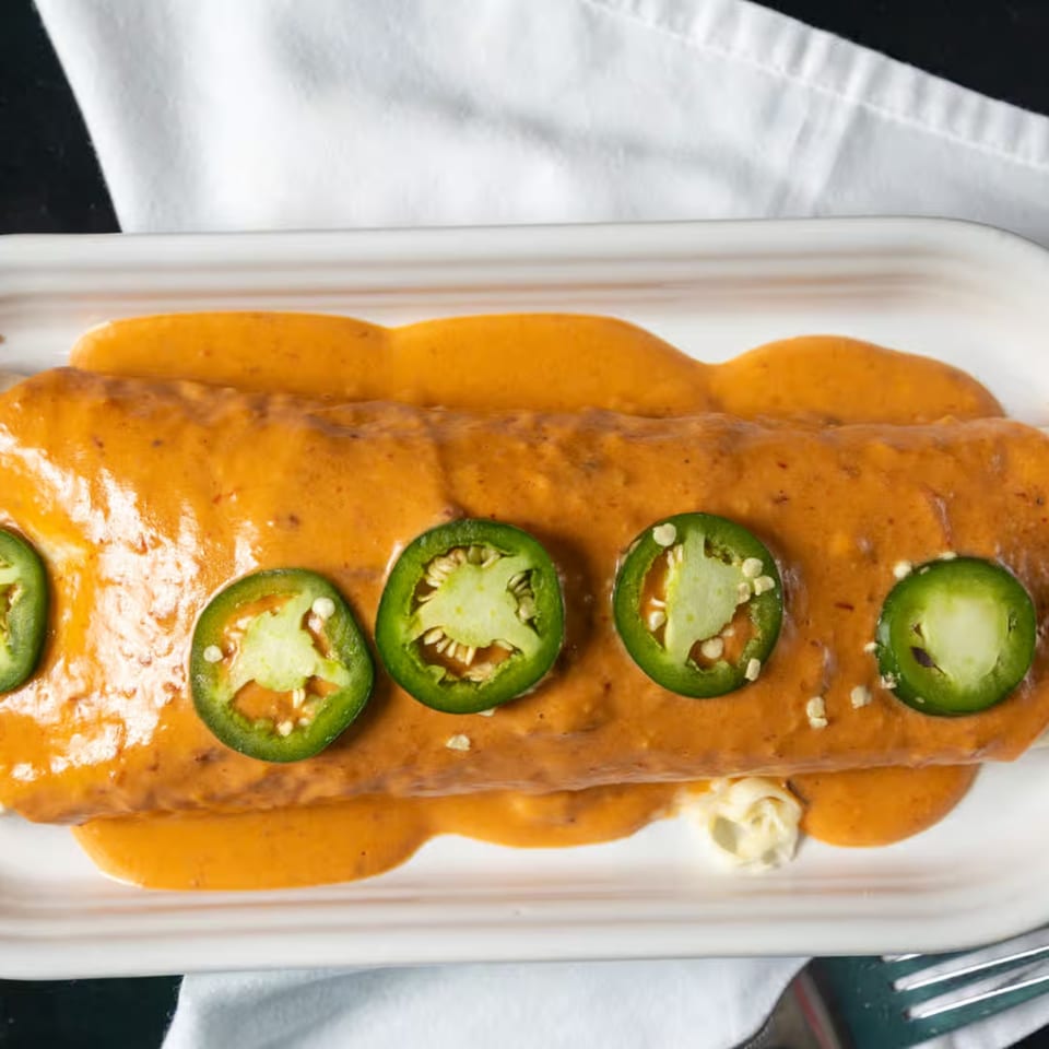 Casa Agave's burrito smothered in orange sauce and topped with fresh jalapeño slices.