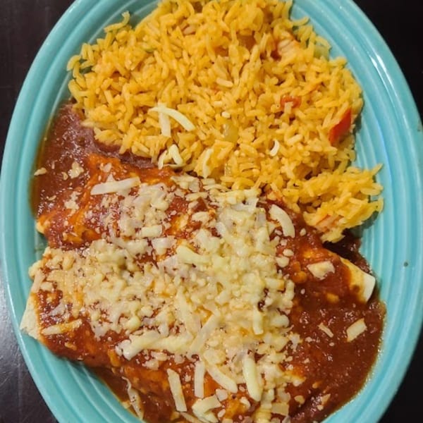 Casa Agave's enchiladas covered in red sauce and cheese, served with a side of Mexican rice.